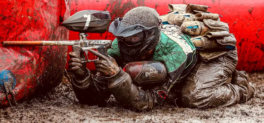 Joueur de paintball en action derrière un obstacle